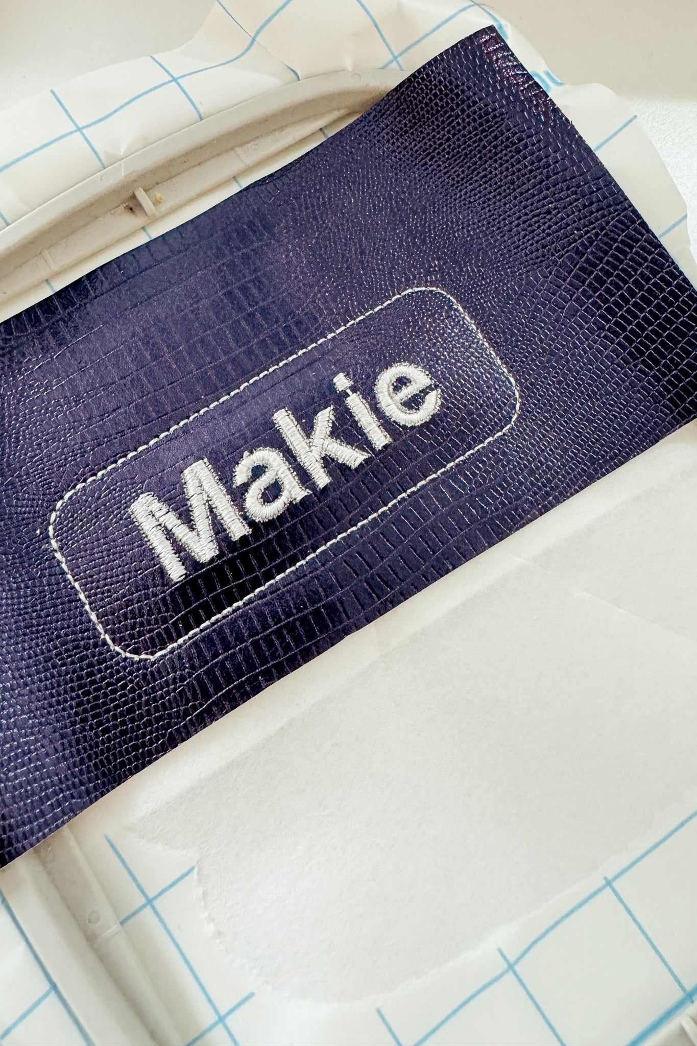 Fertig besticktes Kunstleder mit dem Wort "Makie" stabilisiert mit Filmoplast