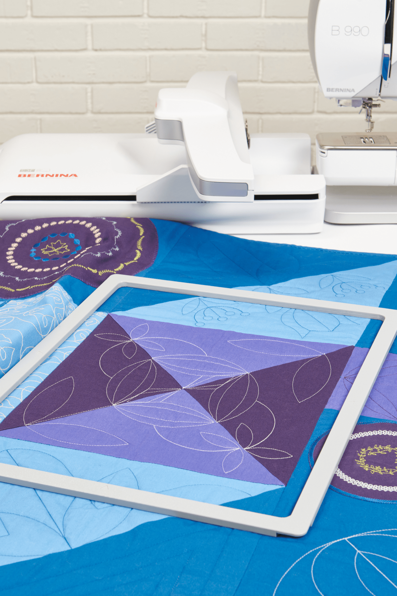 BERNINA Giant Magnet-Stickrahmen auf einem Quilt vor der BERNINA B 990 mit Stickmodul.