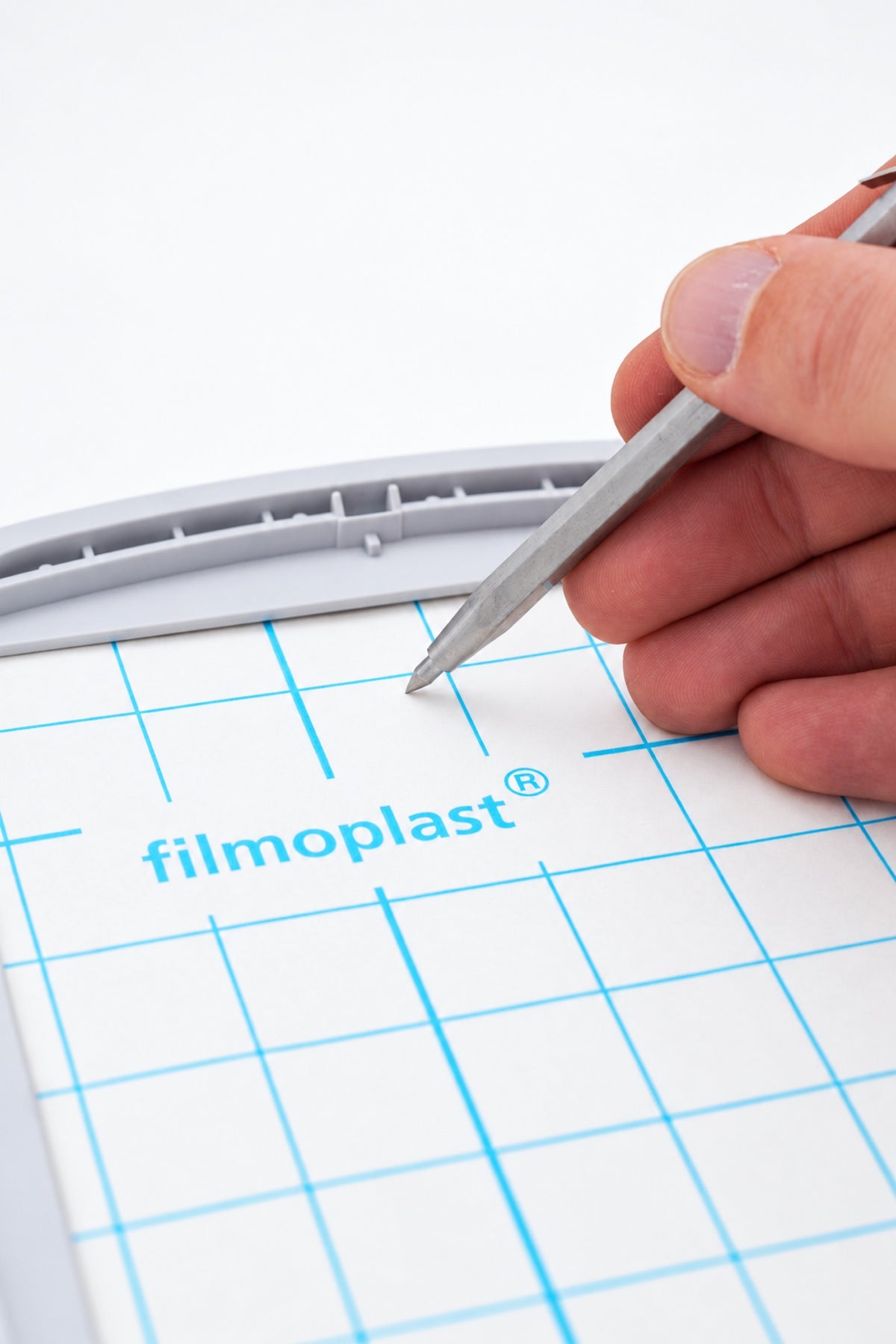 Gunold SLIT-PEN ridser beskyttelsespapiret på FILMOPLAST i en broderiramme