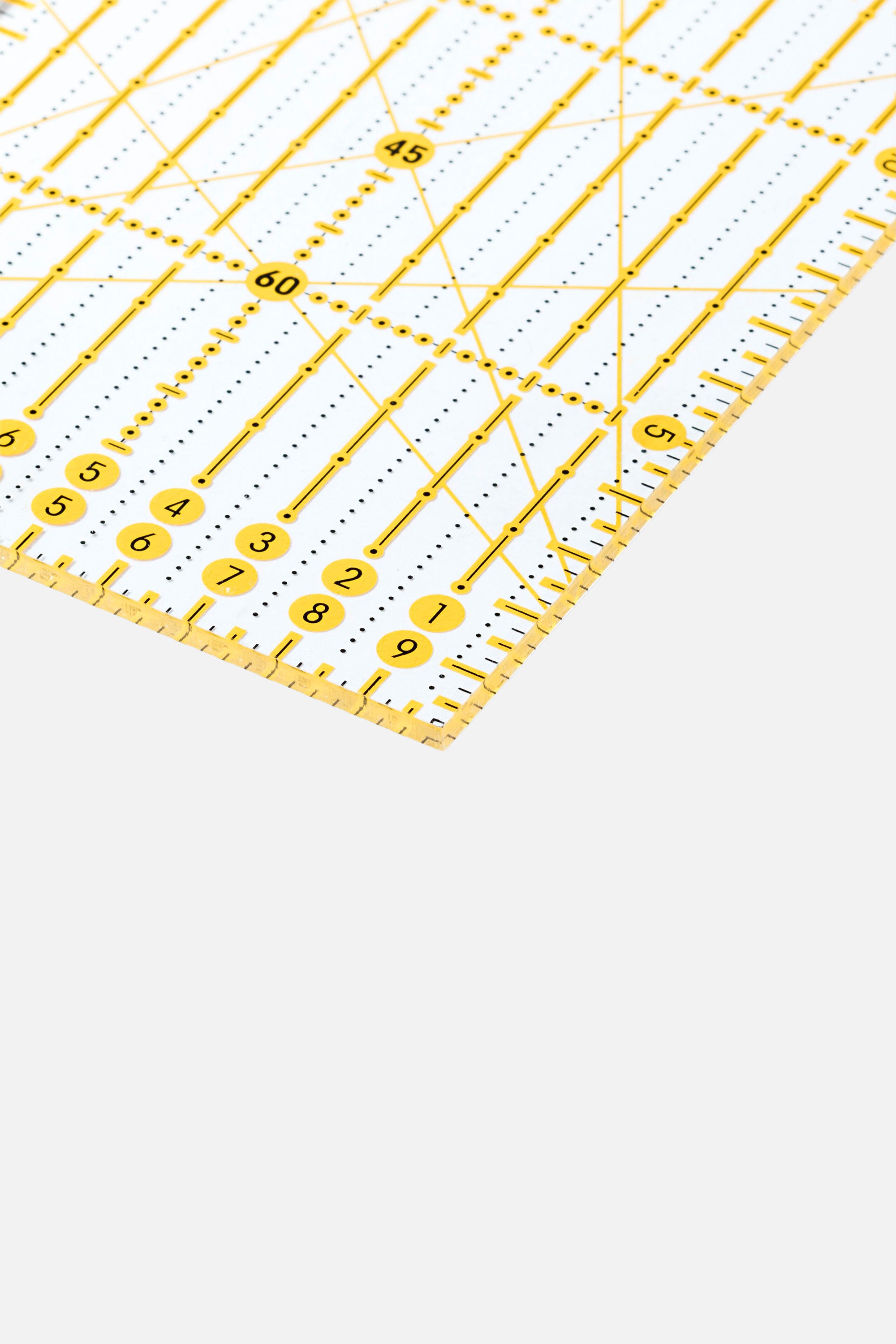 Nahaufnahme einer Lineal-Ecke mit Zentimeter-Skala, Rasterlinien und Winkelmarkierungen (u. a. 45°/60°) des Omnigrid Lineals.
