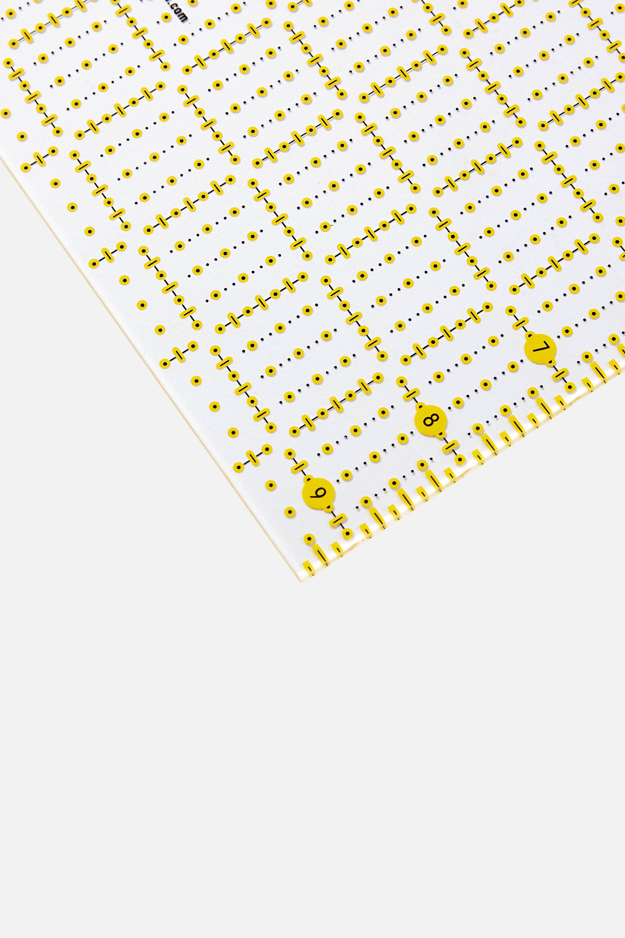 Detailaufnahme der Ecke des PRYM Omnigrid Universal-Lineals mit Inch-Skalierung, Rasterpunkten und Markierungen für präzises Zuschneiden.