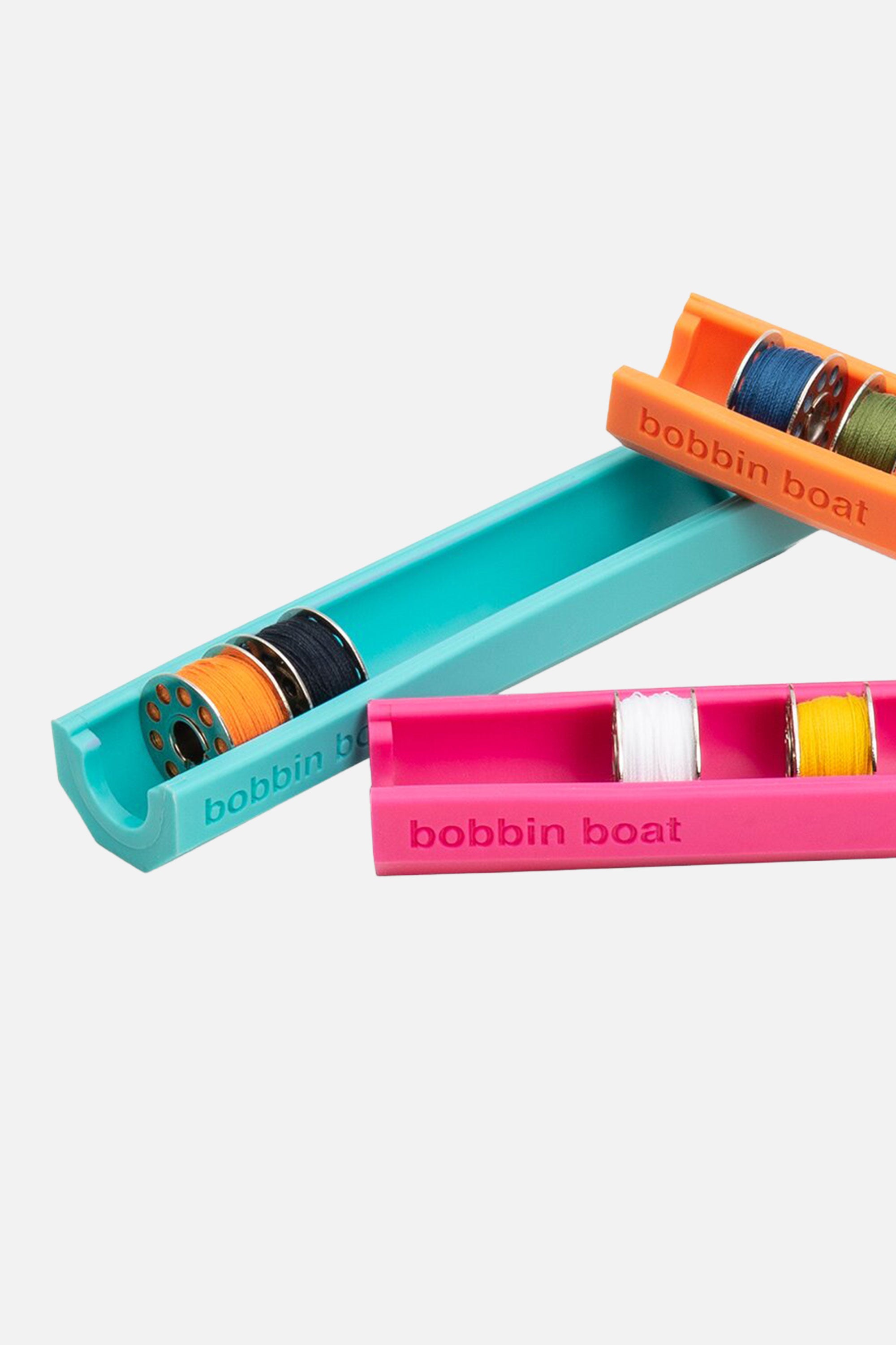 Prym Love Bobbin Boat Spulenhalter in orange, pink und türkis – teilweise mit Nähmaschinenspulen bestückt