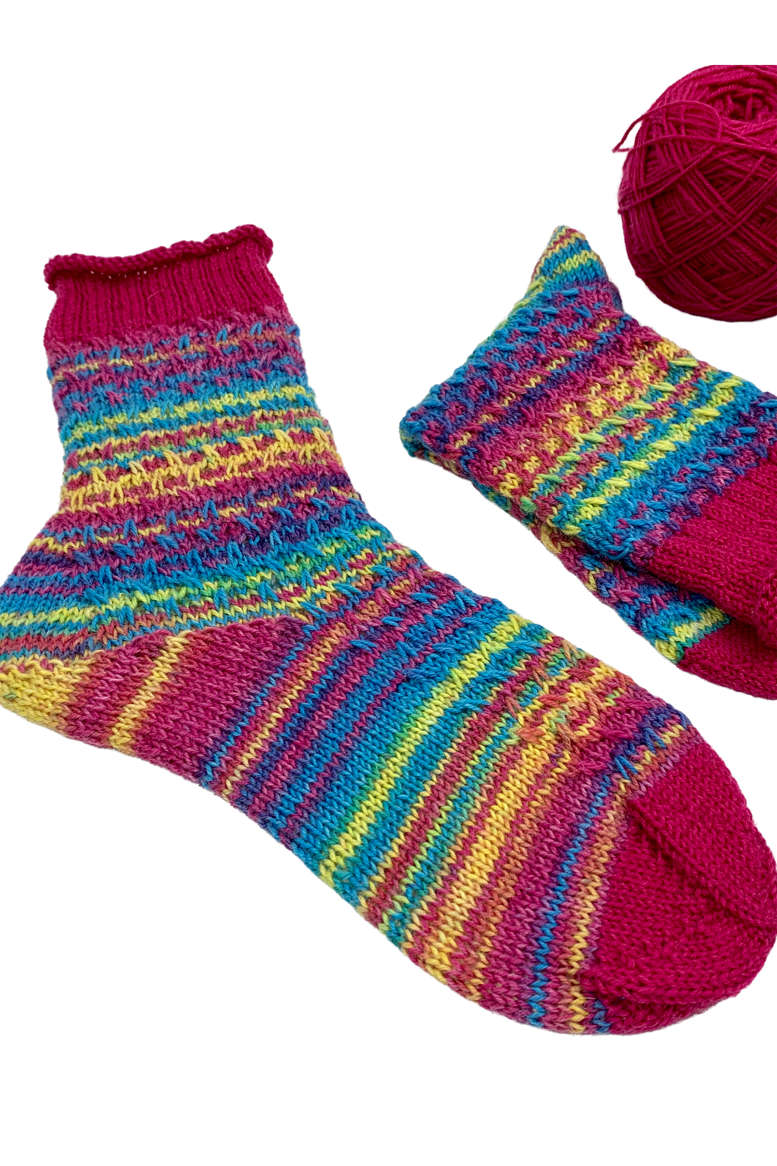 Colourful 15-Years-Socks in gradient yarn beside a matching ball of yarn
