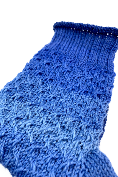 Close-up of the diagonal slip-stitch pattern on the blue 15-Years-Socks